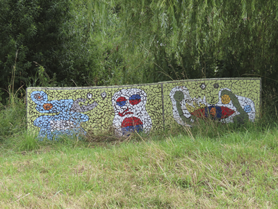 907059 Afbeelding van de achterzijde van de met mozaïeken versierde bank ter hoogte van het Kloosterpark (achtergrond) ...